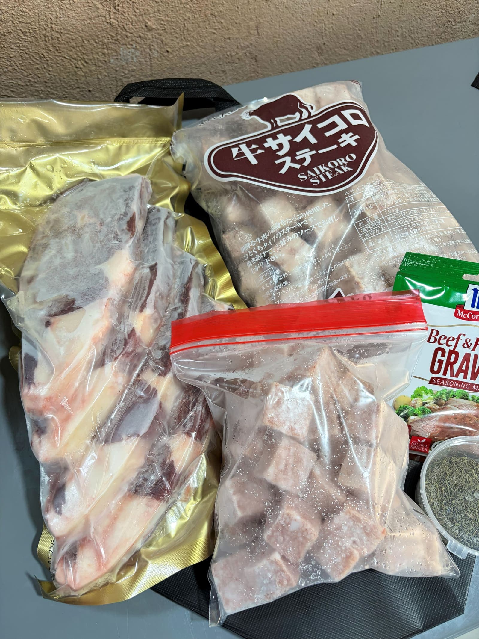 NK Foods saikoro wagyu in its original Japanese packaging beside a butter-aged ribeye pack